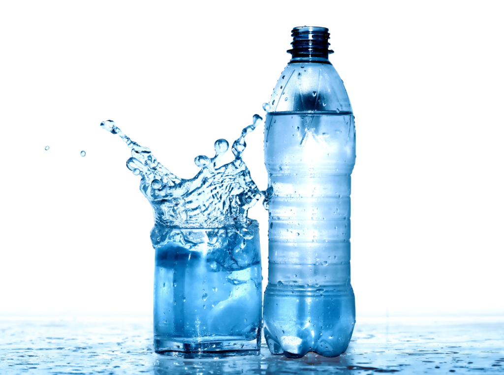 plastic bottle sitting by a glass full of water