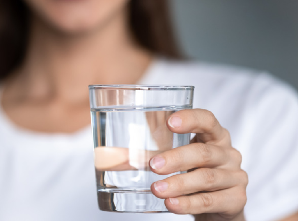 a woman holding a glass of water