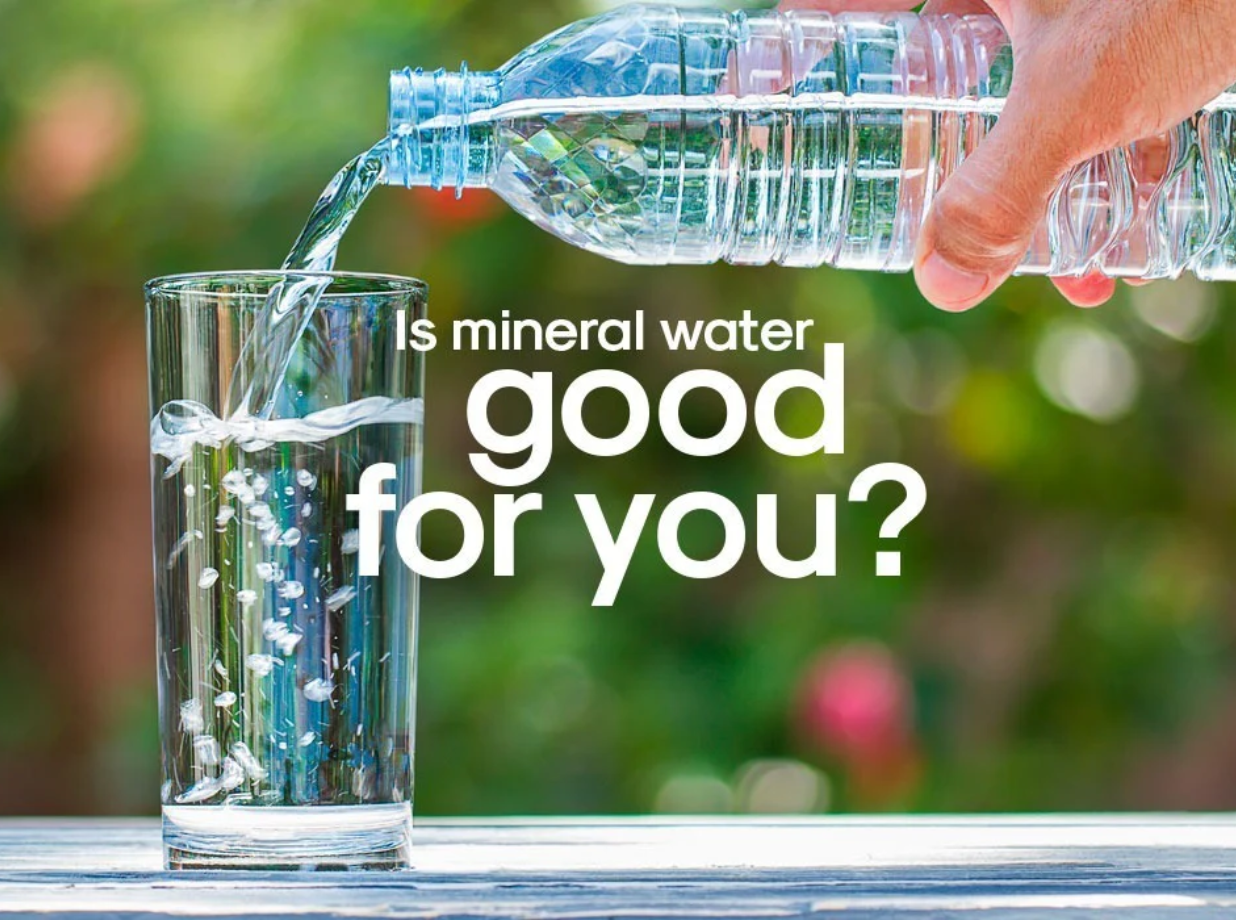 a person pouring mineral water into a glass from a water bottle